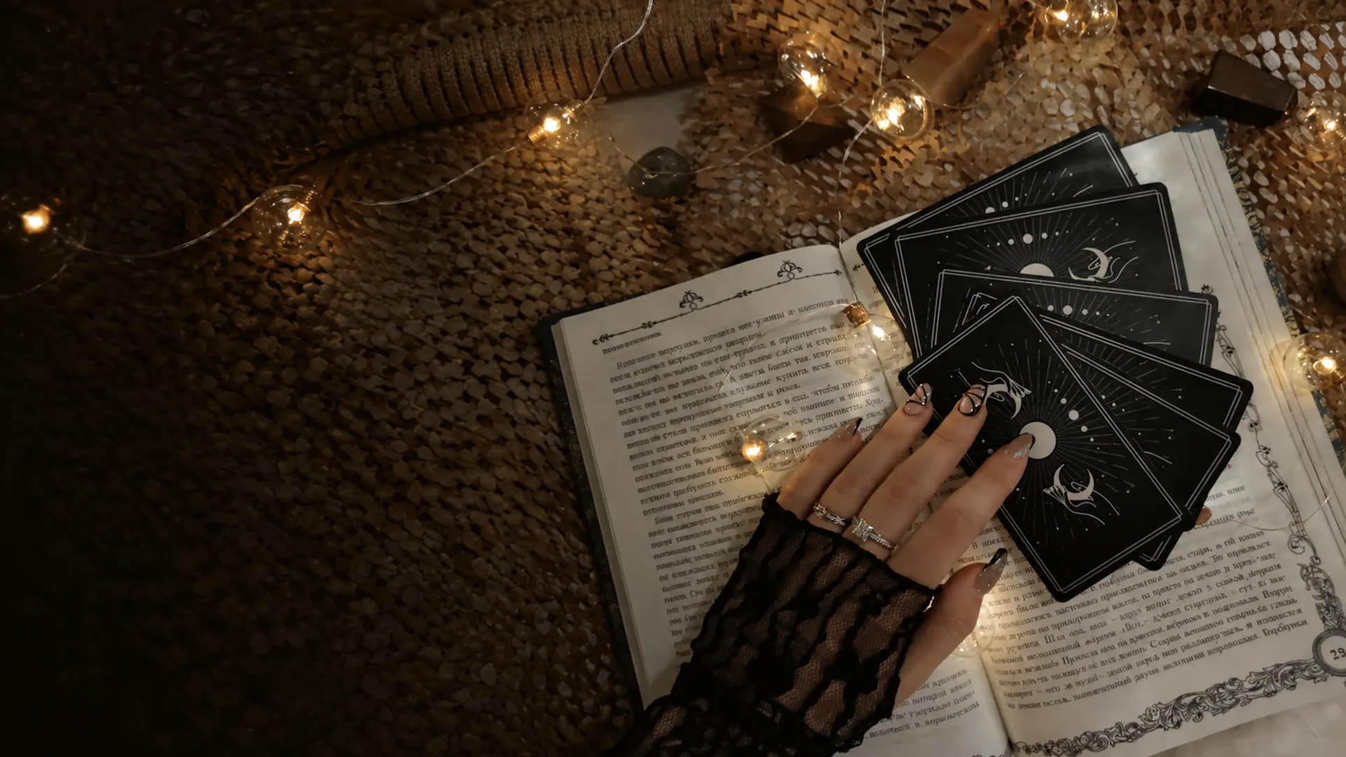 Livre ancien ouvert et cartes noires éclairés par de petites lumières