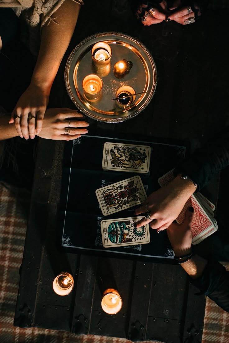 Vue de dessus d'un tirage de trois cartes de tarot entouré de bougies allumées